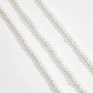Dettaglio di elegante catena di perle finte bianche con perline rotonde e lucide