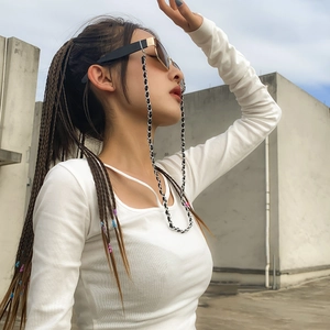 Détail de la chaîne de lunettes en métal entrelacée de cuir PU sur un haut blanc