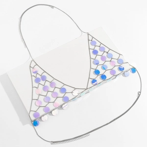 Detailed view of silver body chain with holographic sequins on a white display