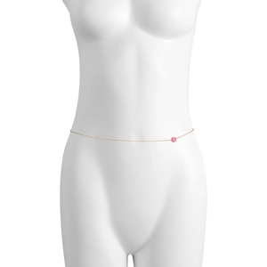 Dettaglio di una catena da vita dorata con un piccolo ciondolo a fiore rosa su manichino