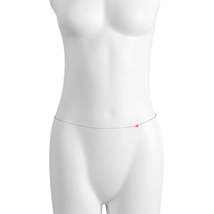 Dettaglio di una sottile catena per il corpo dorata con fiore rosa su un manichino