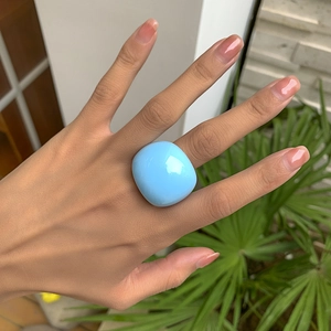 Nahaufnahme des klobigen himmelblauen Acrylrings in trendigem geometrischem Design
