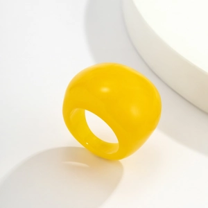 Nahaufnahme eines leuchtend gelben klobigen Acryl-Kuppelrings mit glattem Finish
