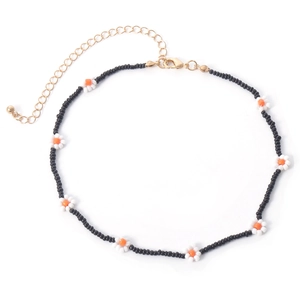Detail van boheemse madeliefje choker met zwarte kralen en goudkleurige sluiting