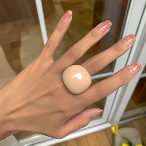 Nahaufnahme eines klobigen nude Harzrings mit glatter Textur und minimalistischem Design