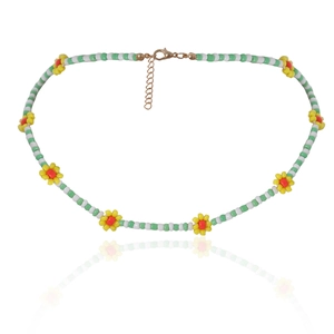 Detail van kralenmadeliefjesketting met groene zaadjes en gouden karabijnsluiting