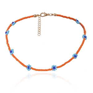 Detailweergave van handgemaakte bohemien kralenketting met oranje en blauwe bloemen
