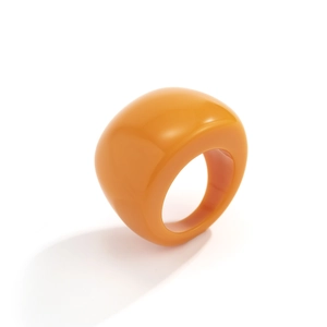 Detailansicht eines übergroßen klobigen orangefarbenen Acrylrings mit Hochglanz-Finish