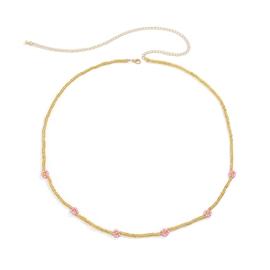 Detail of yellow bead body chain featuring purple flower charms and golden lobster clasp