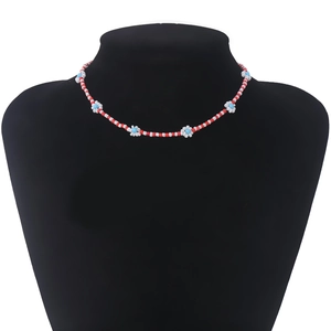 Detail van handgemaakte kralenketting met rode, witte en blauwe madeliefjes patronen
