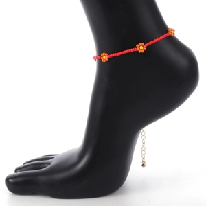 Rode kralen enkelband met oranje bloemen en een verstelbare goudkleurige verlengketting