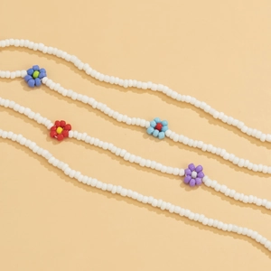 Detail of bohemian daisy waist chain with white beads and colorful floral charms
