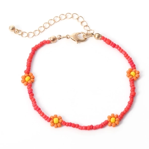 Detail van boho rode kralenketting met oranje madeliefjes en gouden karabijnsluiting