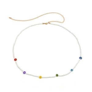 Detail of colorful bead daisy flowers on a white bohemian body chain with gold clasp