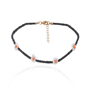 Detail van kralen choker ketting met madeliefjes, zwarte kralen en gouden sluiting