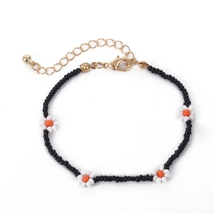 Detail van kralenketting met madeliefjes, gouden karabijnsluiting en verstelbare ketting