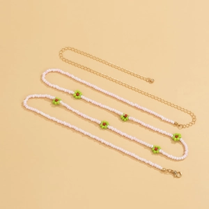 Detail of bohemian daisy waist chain with pink beads and adjustable gold metal clasp