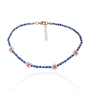 Detail van blauwe kralenketting met madeliefjes en verstelbare gouden karabijnsluiting op wit