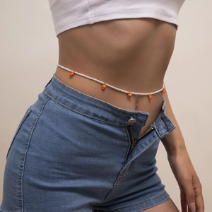 Chaîne de taille en perles avec pendentifs fleurs orange portée sur un mannequin