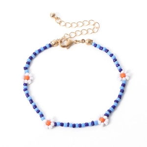 Detail van blauwe kralenketting met witte madeliefjespatronen en verstelbare karabijnsluiting