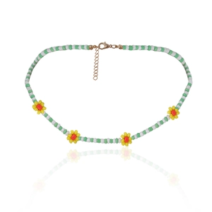 Detail van kleurrijke madeliefjes kralenketting met groene kralen en gouden sluiting