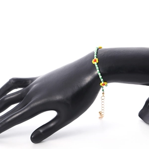 Detail van de bohemien madeliefjes kralenketting met groene kralen en gouden karabijnsluiting