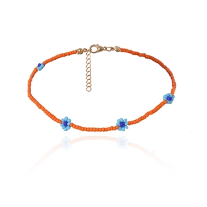Detail van de handgemaakte boheemse kralenketting met oranje kralen en blauwe bloemen