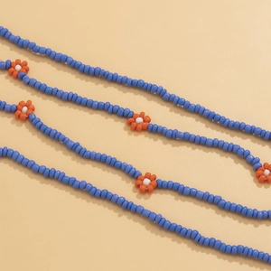 Detail of bohemian daisy waist chain with blue beads and orange floral patterns