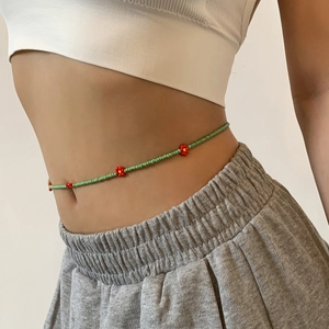 Detail of bohemian waist chain with green seed beads and daisy flower patterns on a model