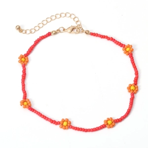 Detail van bohemien rode kralenketting met oranje bloemen en gouden karabijnsluiting