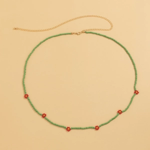 Detail of bohemian green seed bead waist chain with red daisy floral accents and lobster clasp