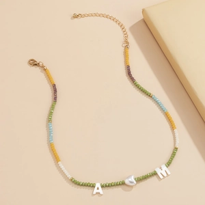 Detail van kleurrijke kralenketting met zilveren hart hanger en A-M letterkralen