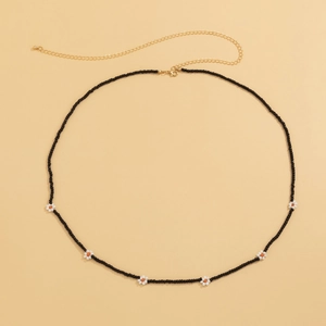 Detail of handmade beaded waist chain with white daisies and golden lobster clasp