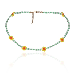 Detail van de madeliefjesketting met witte en groene kralen en gouden sluiting