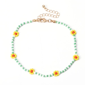Detail van handgemaakte groen-witte kralenketting met kleurrijke madeliefjesbloemen
