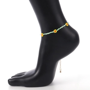 Detail van bohemien kleurrijke madeliefje kralen enkelbandje met gouden verlengketting