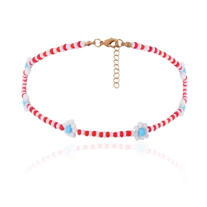 Detail van kleurrijke kralenketting met madeliefjes, rode witte kralen en gouden sluiting