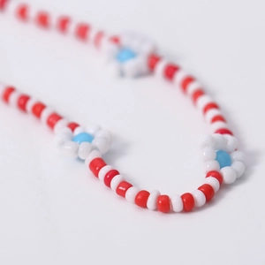 Detail macro-opname van de kleurrijke kralenketting met kleine madeliefjes
