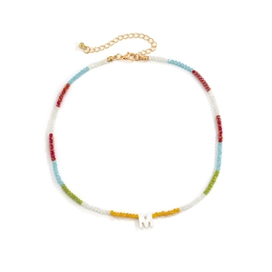 Detail van kleurrijke kristallen kralenketting met een witte M-hanger en gouden sluiting