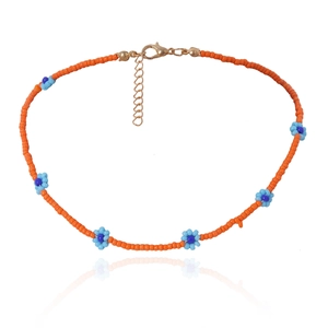 Detail van de oranje kralenketting met blauwe madeliefjes en gouden verstelbare sluiting