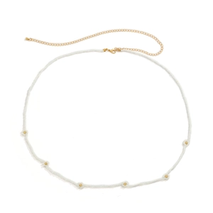 Detail of bohemian white seed bead waist chain with small daisy flower charms and gold clasp