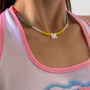 Close-up van bohemien kleurrijke kralen choker ketting met een witte letter M hanger