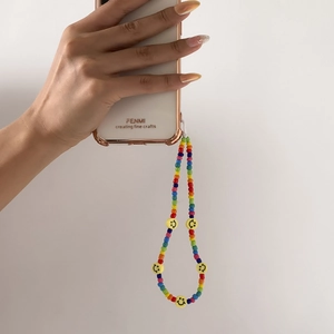 Colorful beaded phone lanyard featuring yellow smiley face charms held against a phone
