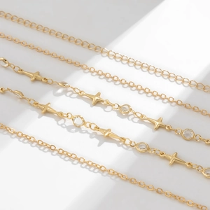 Detailed view of gold multi-layer body chains with cross charms and clear crystals