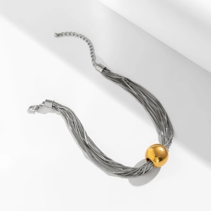 Détail de colliers multicouches en argent avec un grand pendentif en boule dorée polie