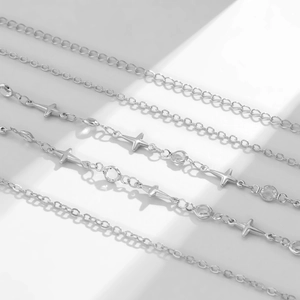 Detailed close-up of silver metal waist chains with cross charms and sparkling zircon stones