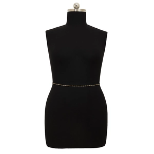 Detailed close-up of golden minimalist cross-link body chain on a black mannequin display