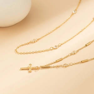 Macro shot of gold cross body chain featuring sparkling rhinestones and delicate metal link details