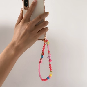 Detailed macro view of colorful macaron-colored beads and star charms on phone strap