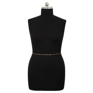 Close-up of golden body chain with colorful heart-shaped charms on a black mannequin